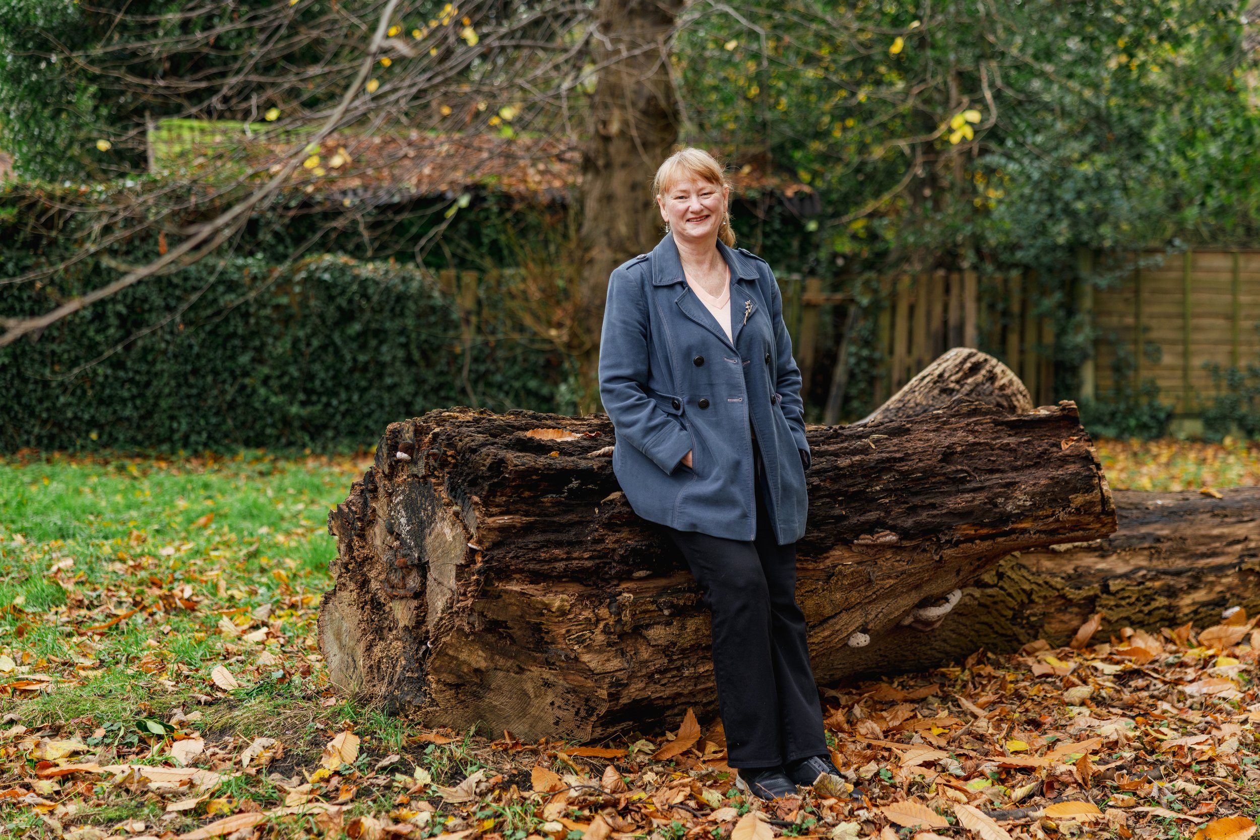 Jac standing against large log in urban park