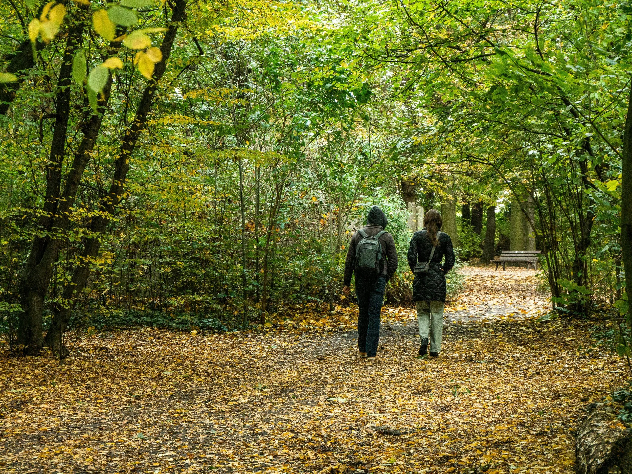 two people walking outdoors speaking privately