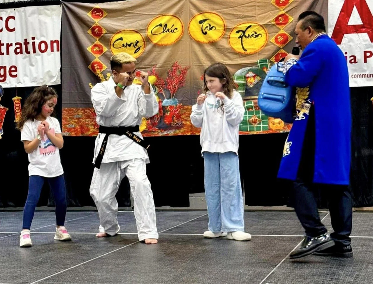Sensei Ty demonstrating techniques to two volunteers from the crowd 2024