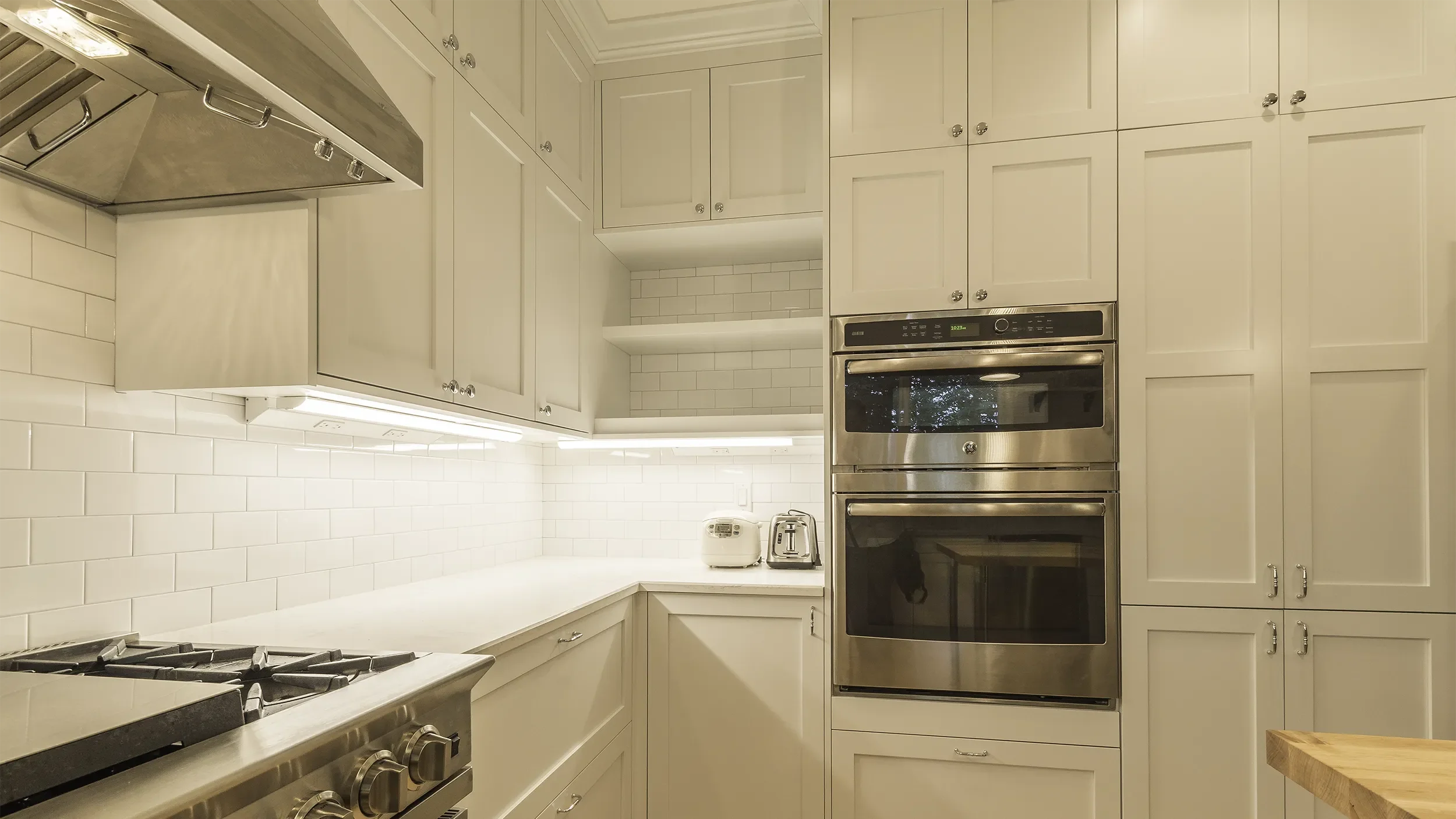 redmond-kitchen-remodel-white-shaker-cabinets-open-shelves-appliance-nook-under-cabinet-lighting.webp