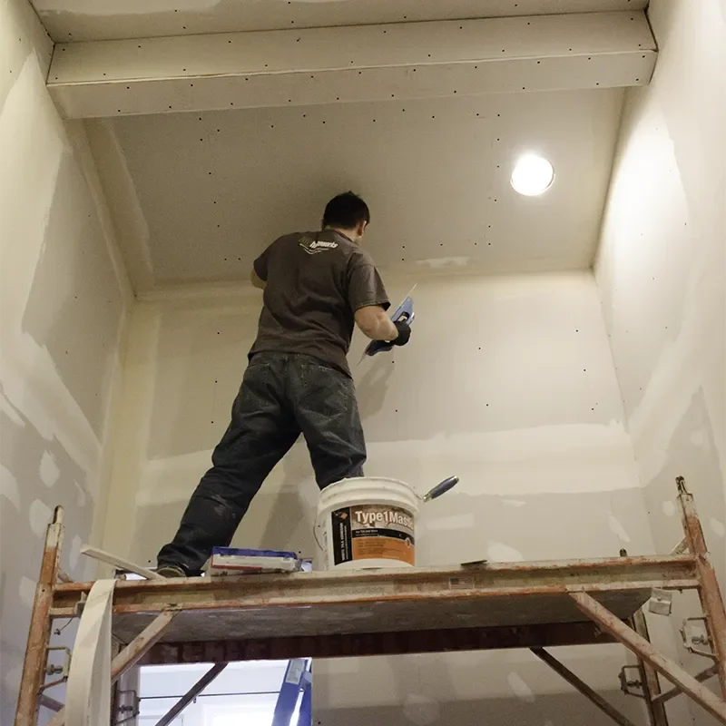 OuA northwest Homeworks team members applies a fresh coat of drywall compound as part of a bathroom remodel