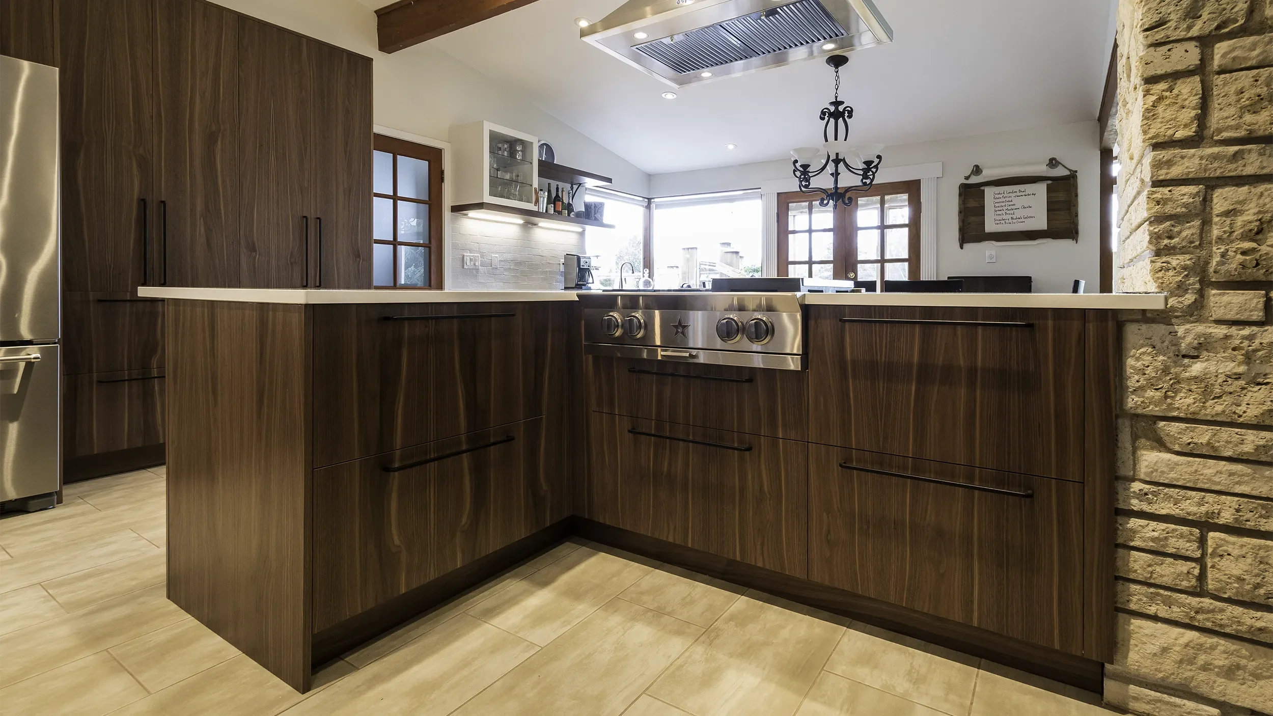 seattle-modern-kitchen-remodel-dark-walnut-cabinets-blue-star-range-top-limestone-chimney.webp