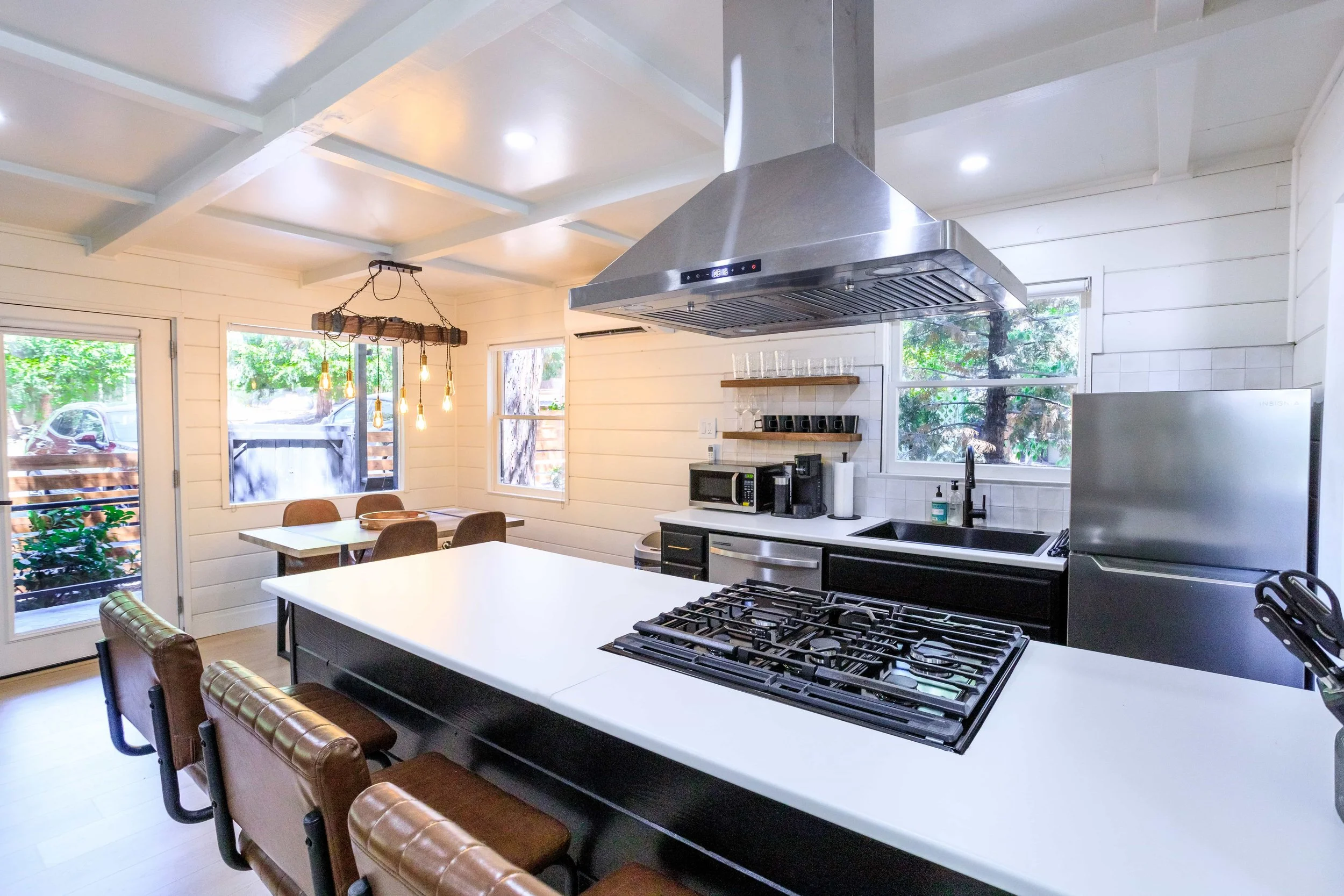 The Pinetree Hotel Idyllwild:  a - Idyllwild California, cozy cabin, mountain resort, mountain getaway Modern bathroom in cabin 1 with dark tiled walls, wooden ceiling, and walk-in shower with glass door and frosted window.