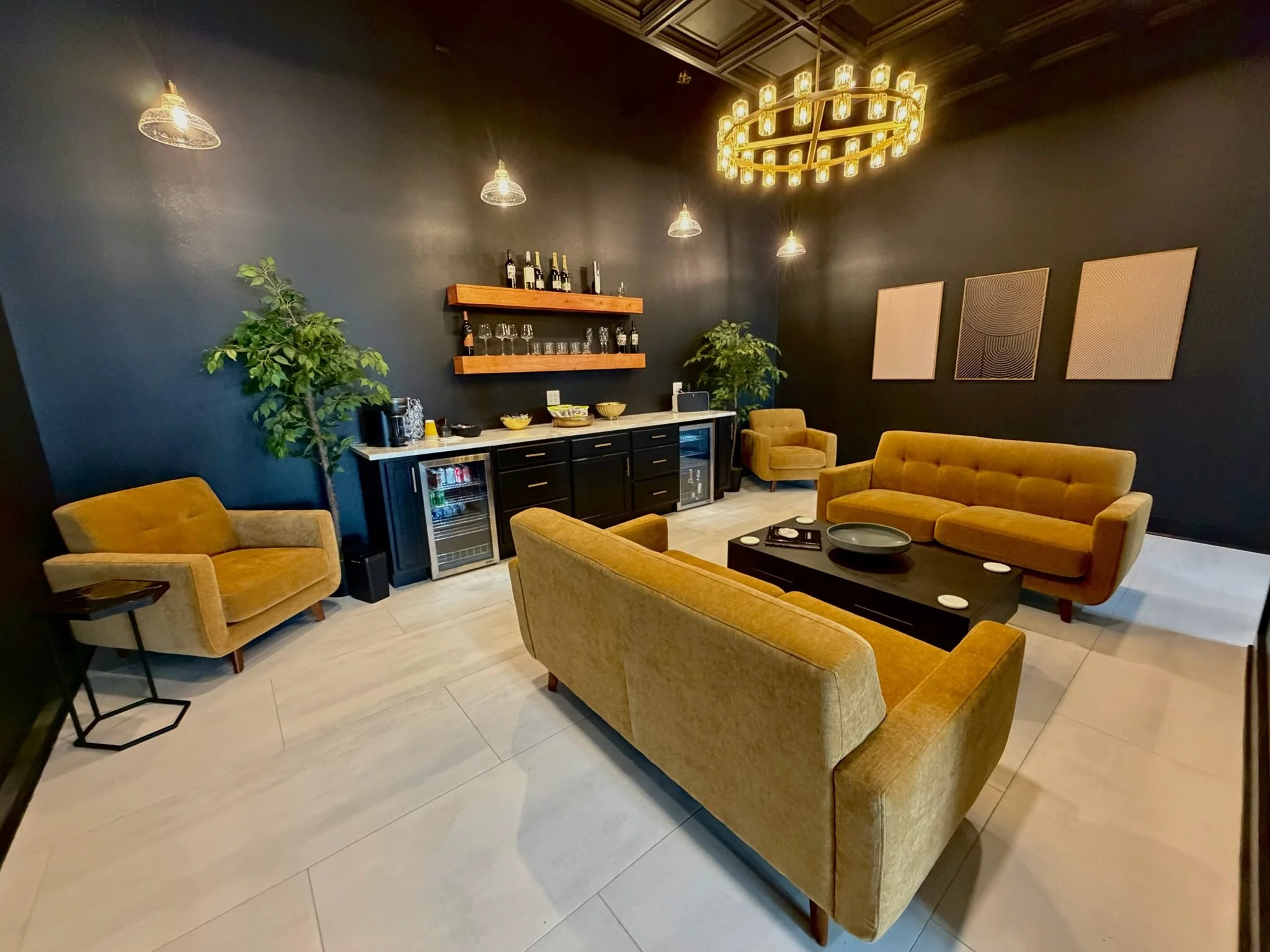 We designed our client waiting area to feel comfortable, elevated, and relaxing from the moment you walk in and head to the back area. With plush velvet seating, warm ambient lighting, and rich, modern finishes, it creates a calm, welcoming atmospher