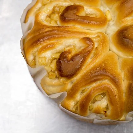 Close-up of a cinnamon roll with swirled dough and caramelized topping.