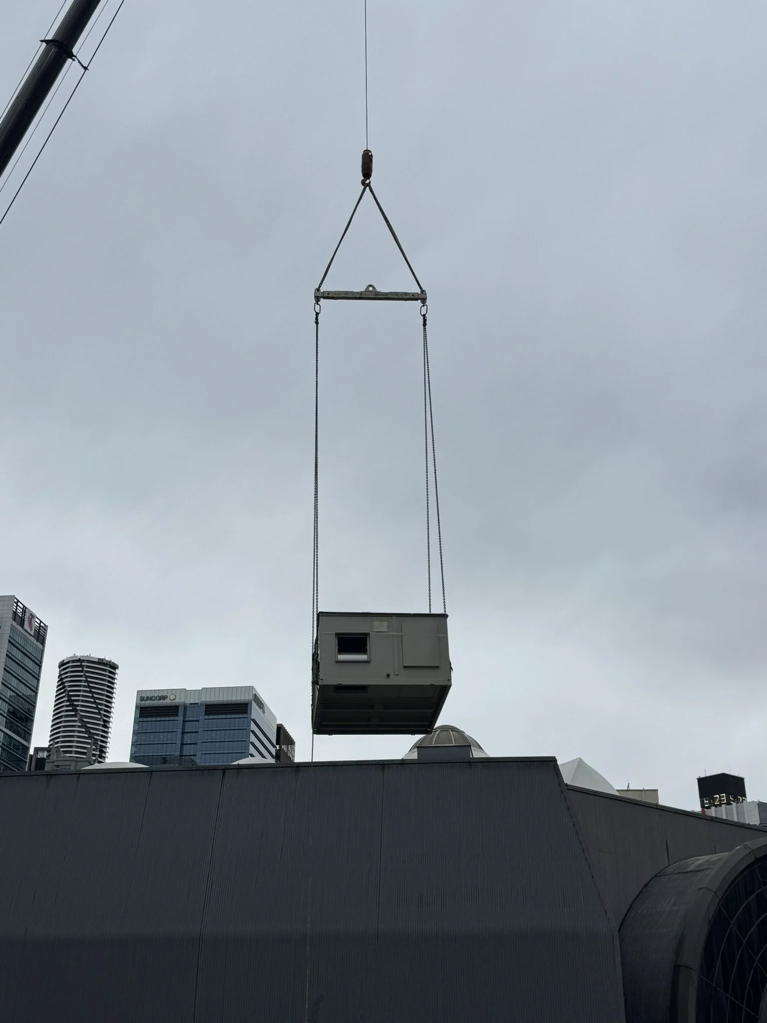 New rooftop package unit being crane lifted for an upgrade on a commercial building in Brisbane CBD.