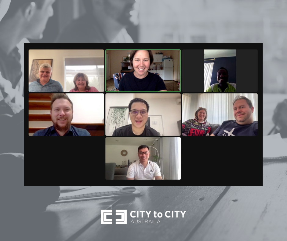 A screenshot of a virtual meeting with nine participants in a video call, set against a background of a desk with a notebook, pen, and glasses, and the logo 'CITY to CITY AUSTRALIA' at the bottom.