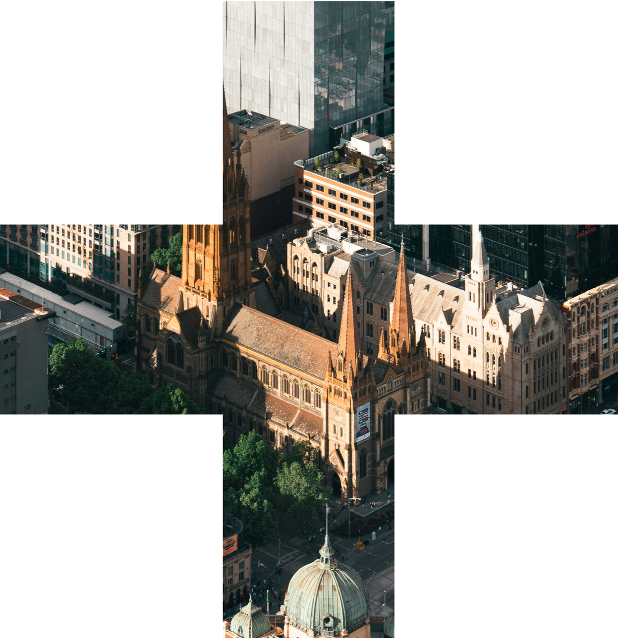 Aerial view of a city block featuring a historic church with tall spires, modern glass buildings, and surrounding skyscrapers.
