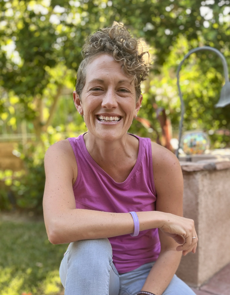 Woman in a magenta tank top smiling.