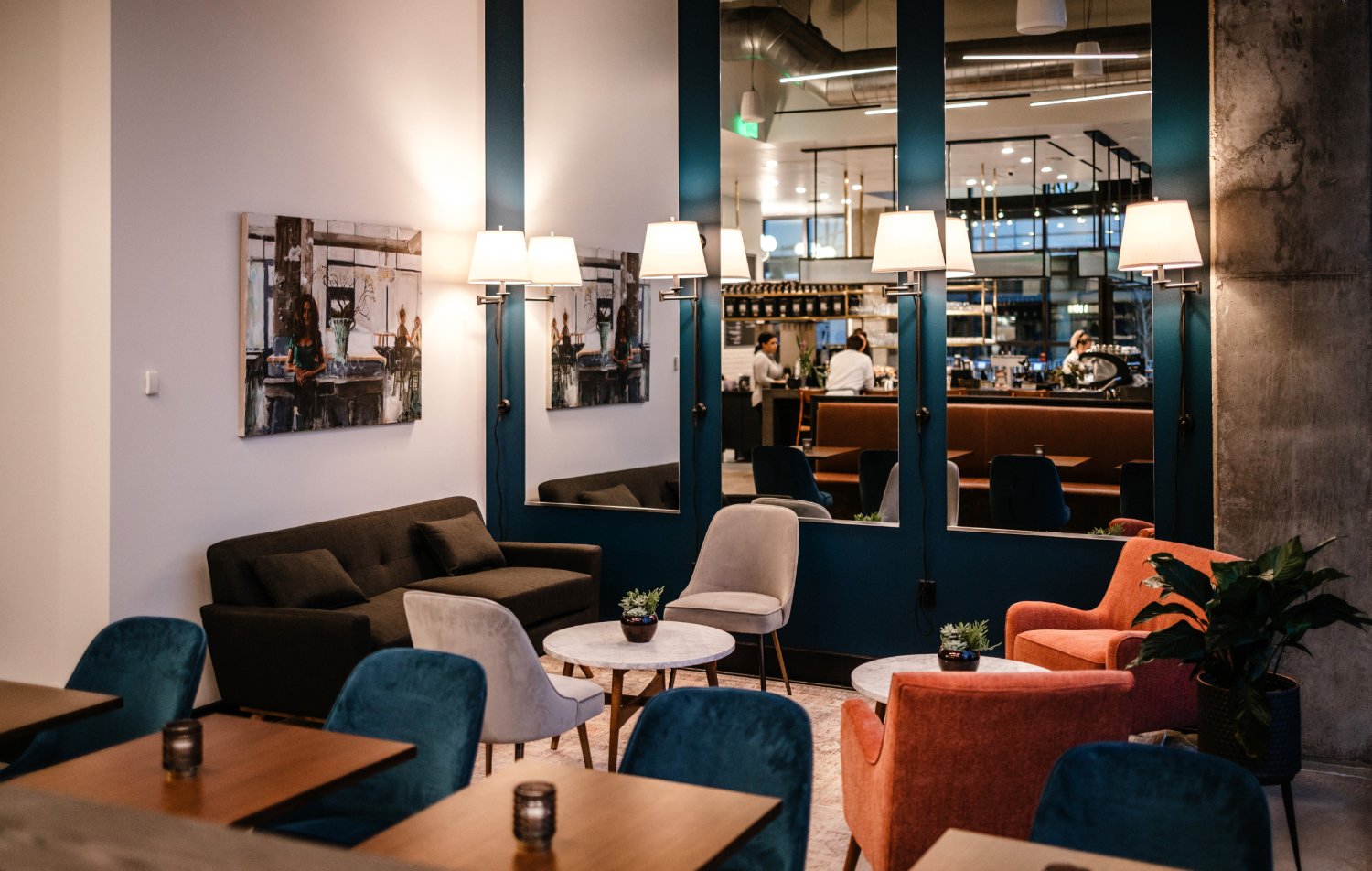 interior view of Frank & Roze lounge with plush seats and a soft seating group with a marble coffee table and another soft seating group with two salmon colored overstuffed chairs