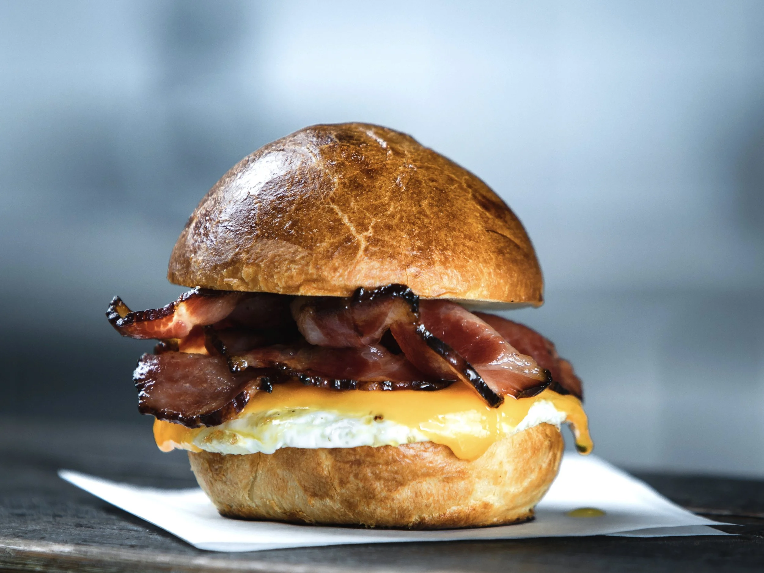 A close up of a yummy bacon egg and cheese morning sandwich