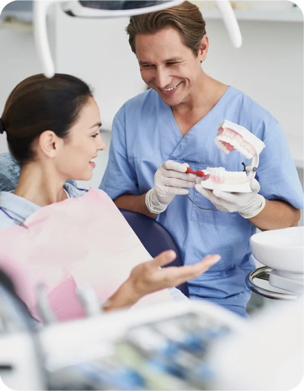 Dentist showing patient a dental model in a dental office.