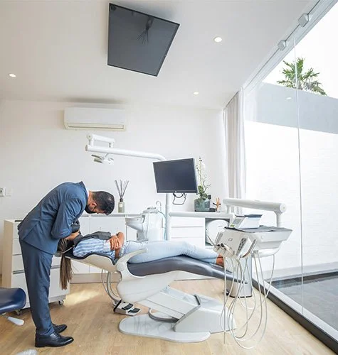 Dentist examining patient's mouth in dental office with modern equipment