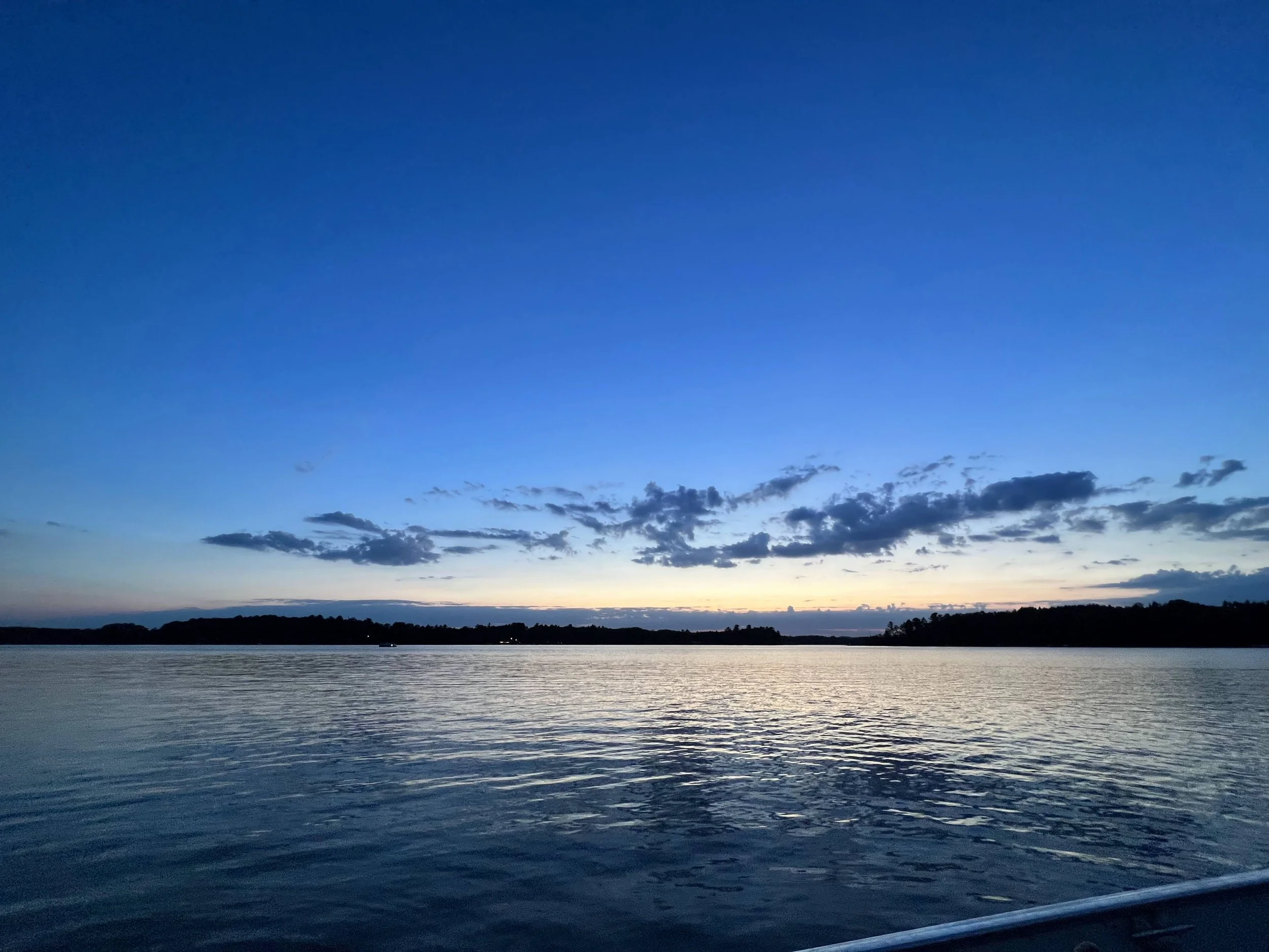 Calm river at sunset with a clear sky and some clouds