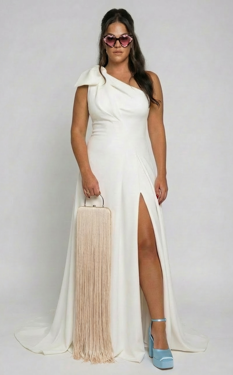 BRIDE wearing a white WEDDING gown with high slit, pink heart-shaped sunglasses, holding a beige bag, wearing blue high heels, and standing against a plain background.