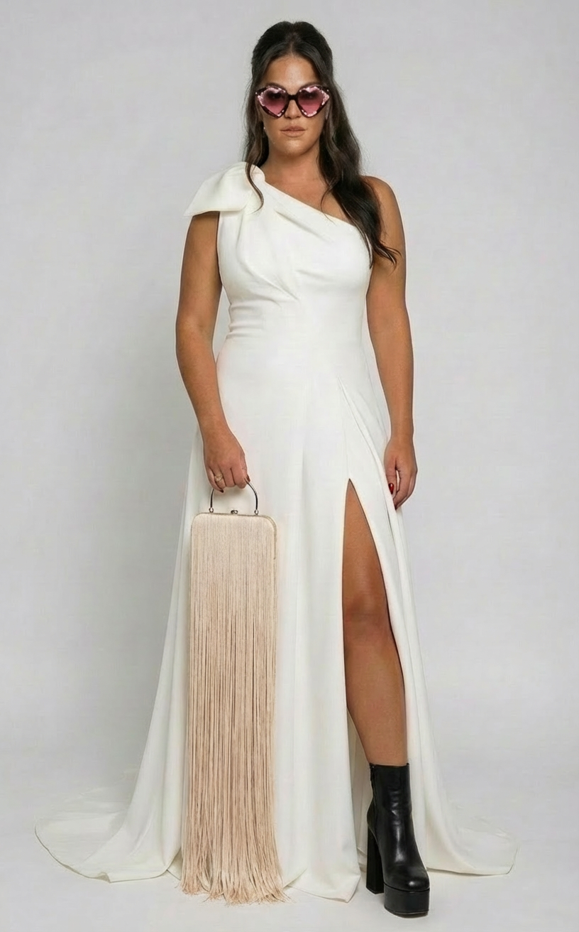 BRIDE wearing a white WEDDING white gown with a high slit, holding a long beige fringe handbag, wearing large pink heart-shaped sunglasses and black platform boots.