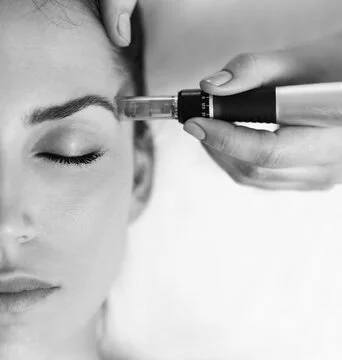 A woman receiving an injection in her forehead, with her eyes closed.