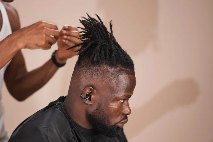 Dreadlocks (Short or Medium Length):
Short or medium locs paired with a clean fade or taper for a modern finish. A bold yet polished style that blends cultural expression with sharp grooming.