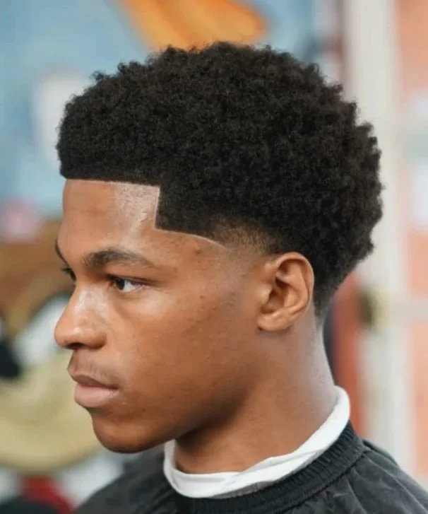 Low Fade with Curls:
A clean low fade that gradually blends into natural curls on top. This style keeps the sides sharp while maintaining volume and texture, giving a fresh and modern look.