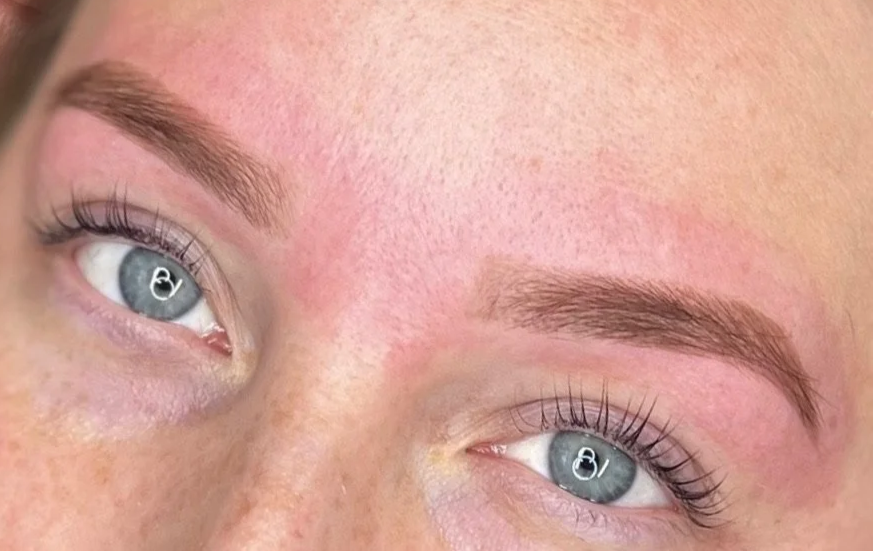 Close-up of a person's face focusing on the eyes, with well-groomed eyebrows and lightly mascaraed eyelashes.