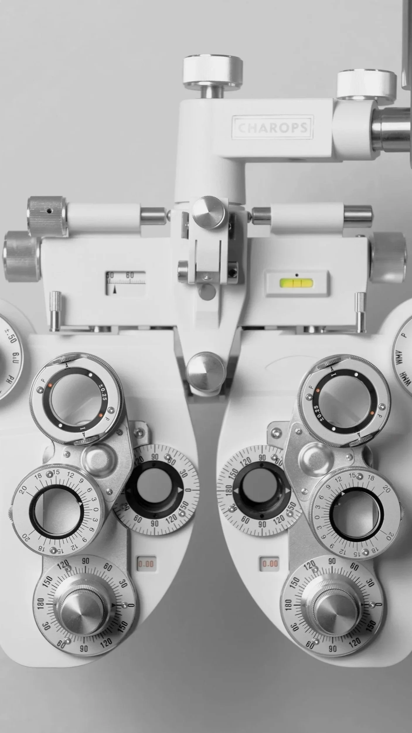 A close-up of vintage optometrist trial frame with multiple dials and adjustment screws.