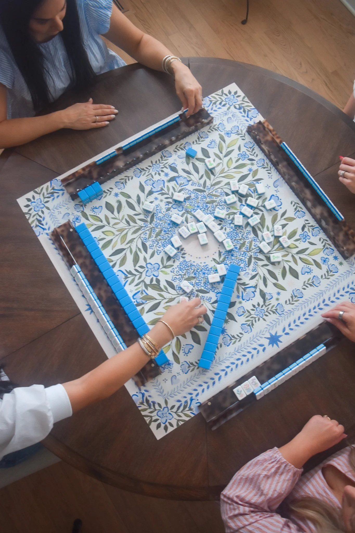 People playing a game of Mahjong at a round table.