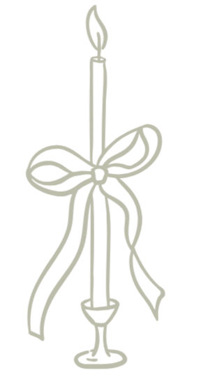 A candle with a flame, decorated with a bow tied around it, in a candle holder.