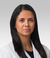 Professional woman with long dark hair wearing a white blazer and black shirt