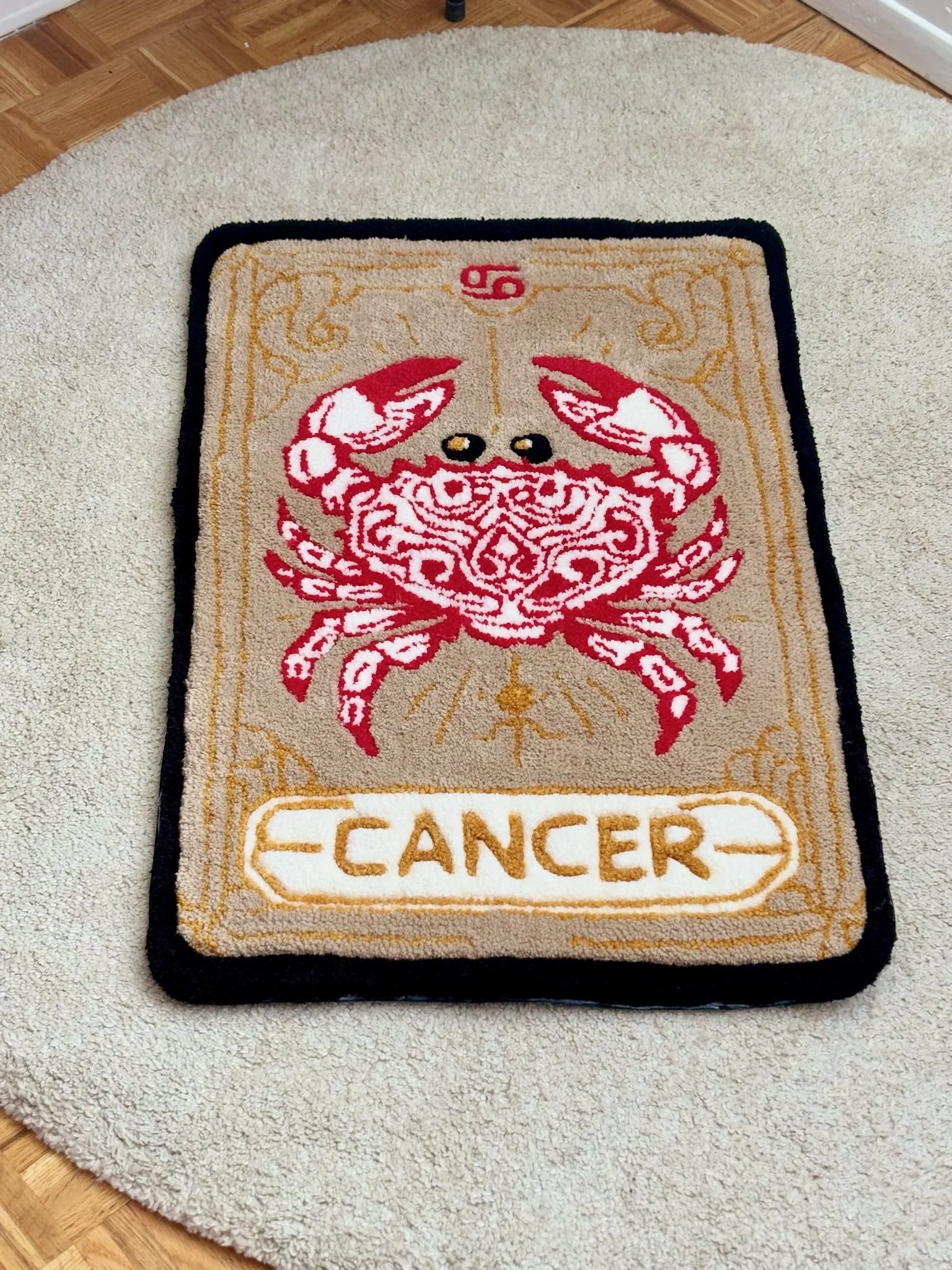 Carved crab design on a beige welcome mat with black border, text reads 'CANCER' at the bottom.