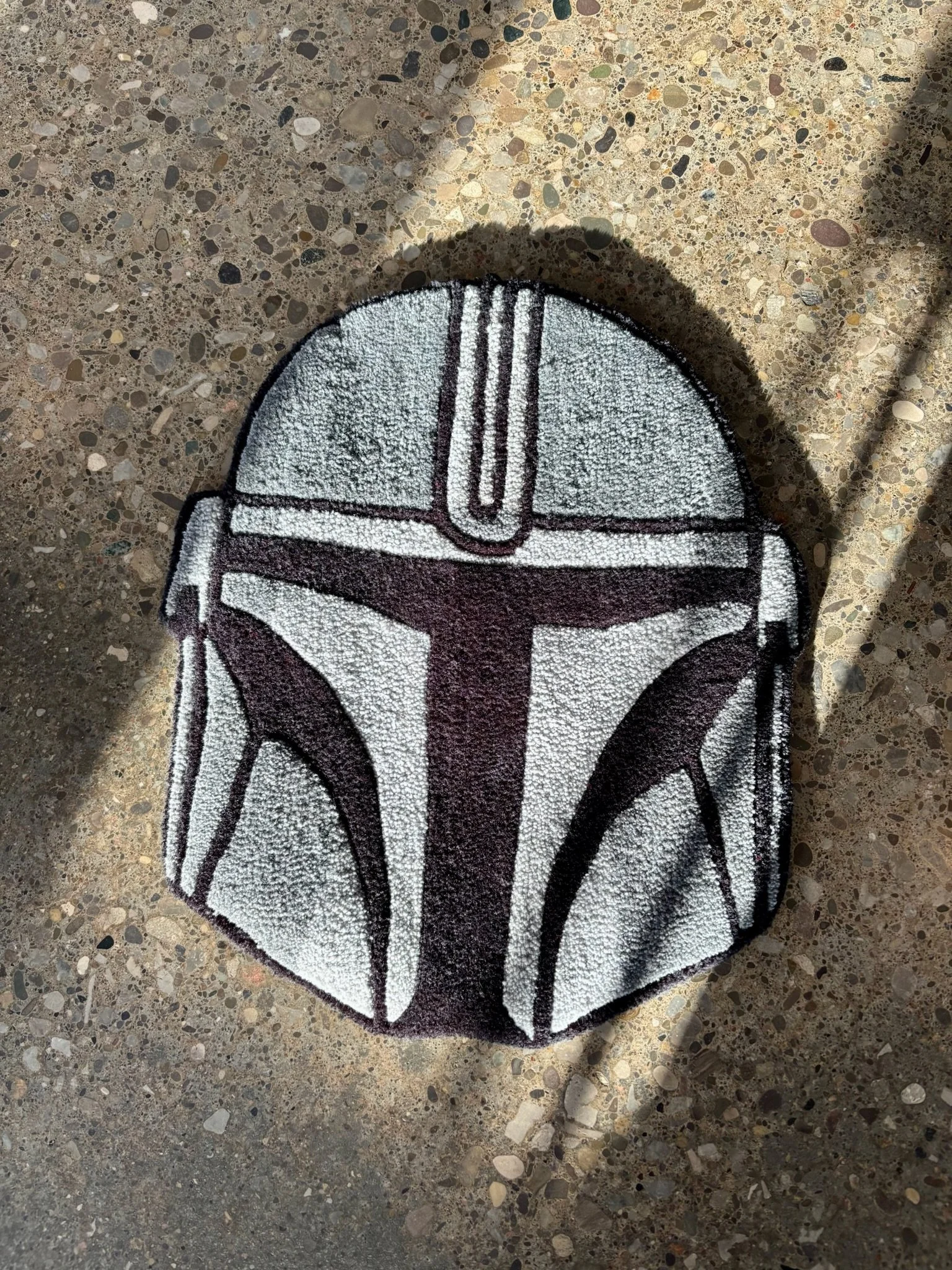 A Star Wars-themed rug on a terrazzo floor.