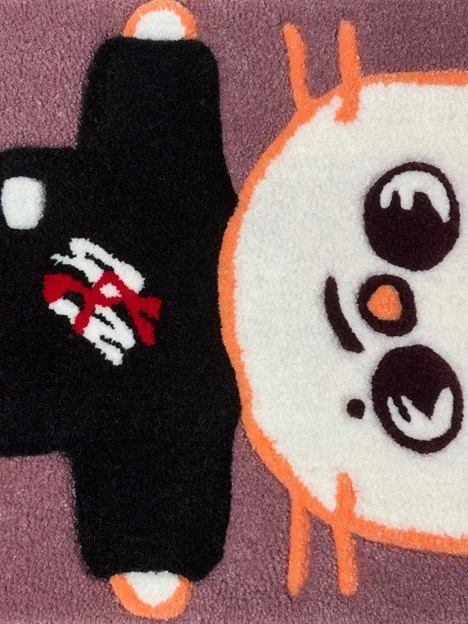 Two plush toys, one black with a red bow and mask design, and one white with large round eyes and a small orange nose, on a pink background.