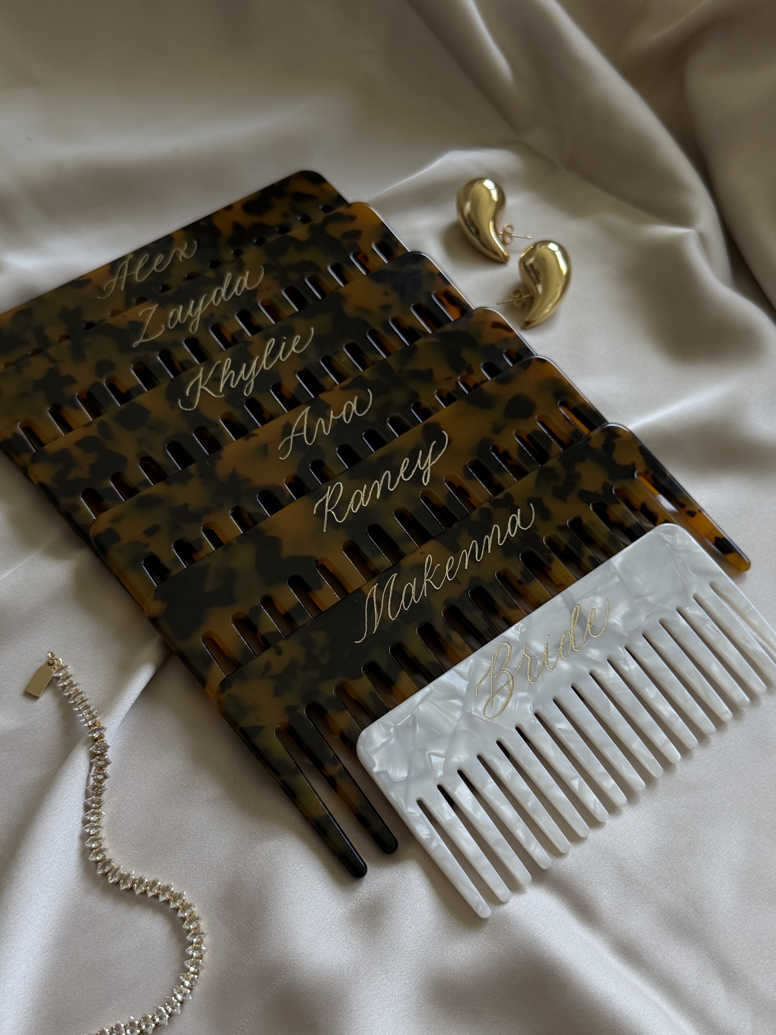 Personalized tortoise hair combs with names in gold calligraphy, styled as bridesmaid gifts.