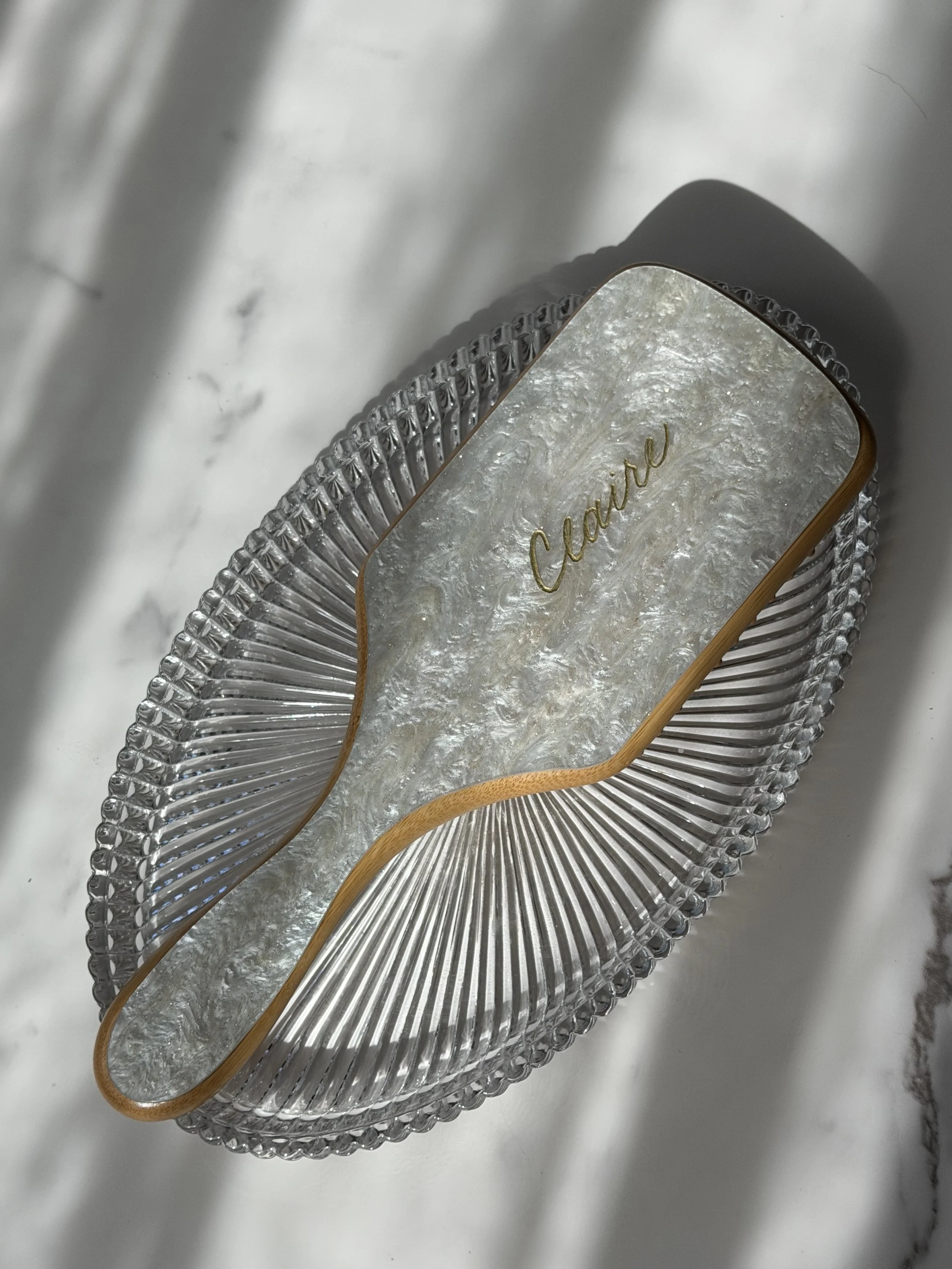 Pearl hairbrush personalized with the name Claire in custom gold calligraphy.