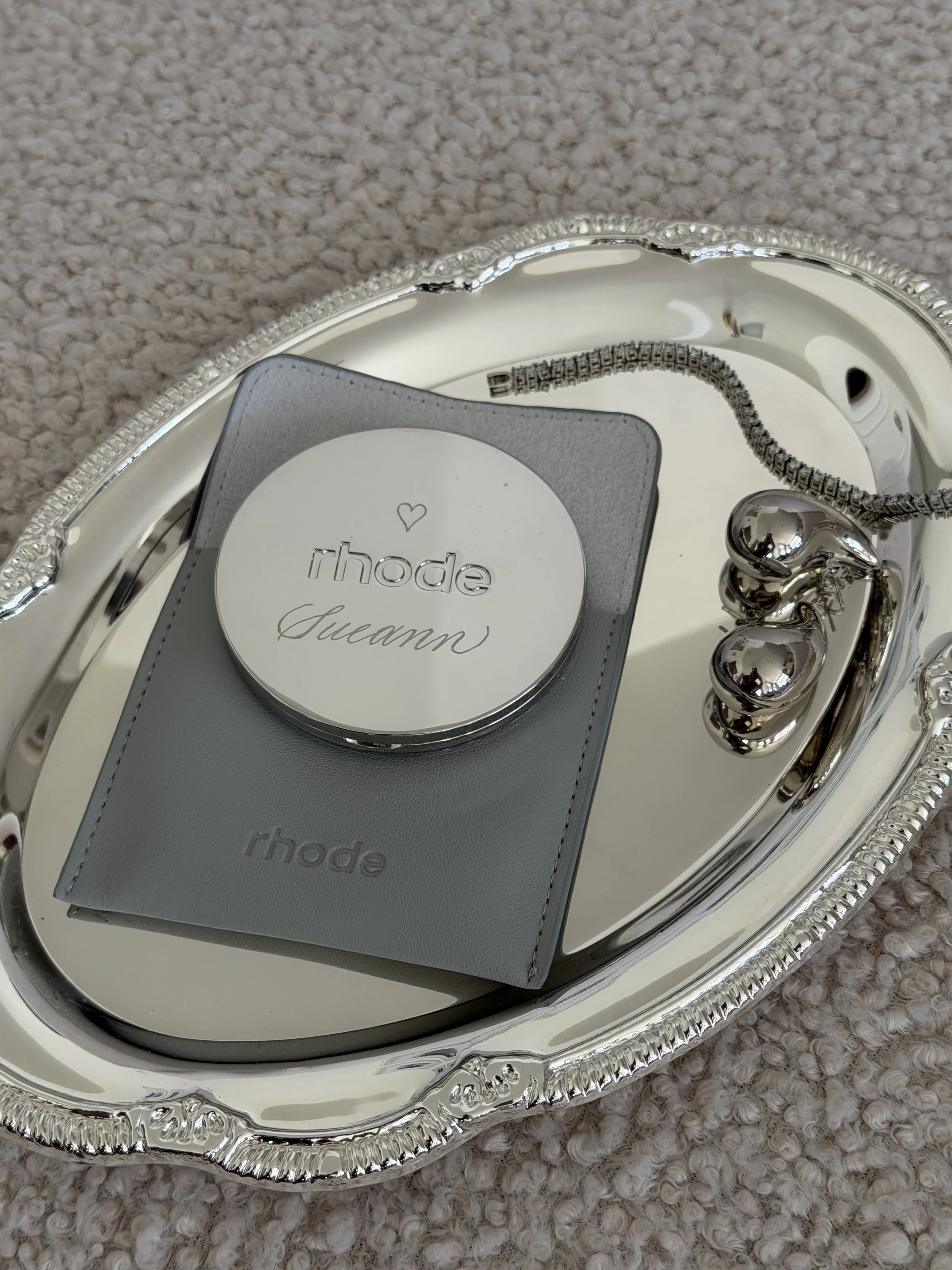 Rhode compact mirror personalized with custom engraving, styled with silver jewelry.