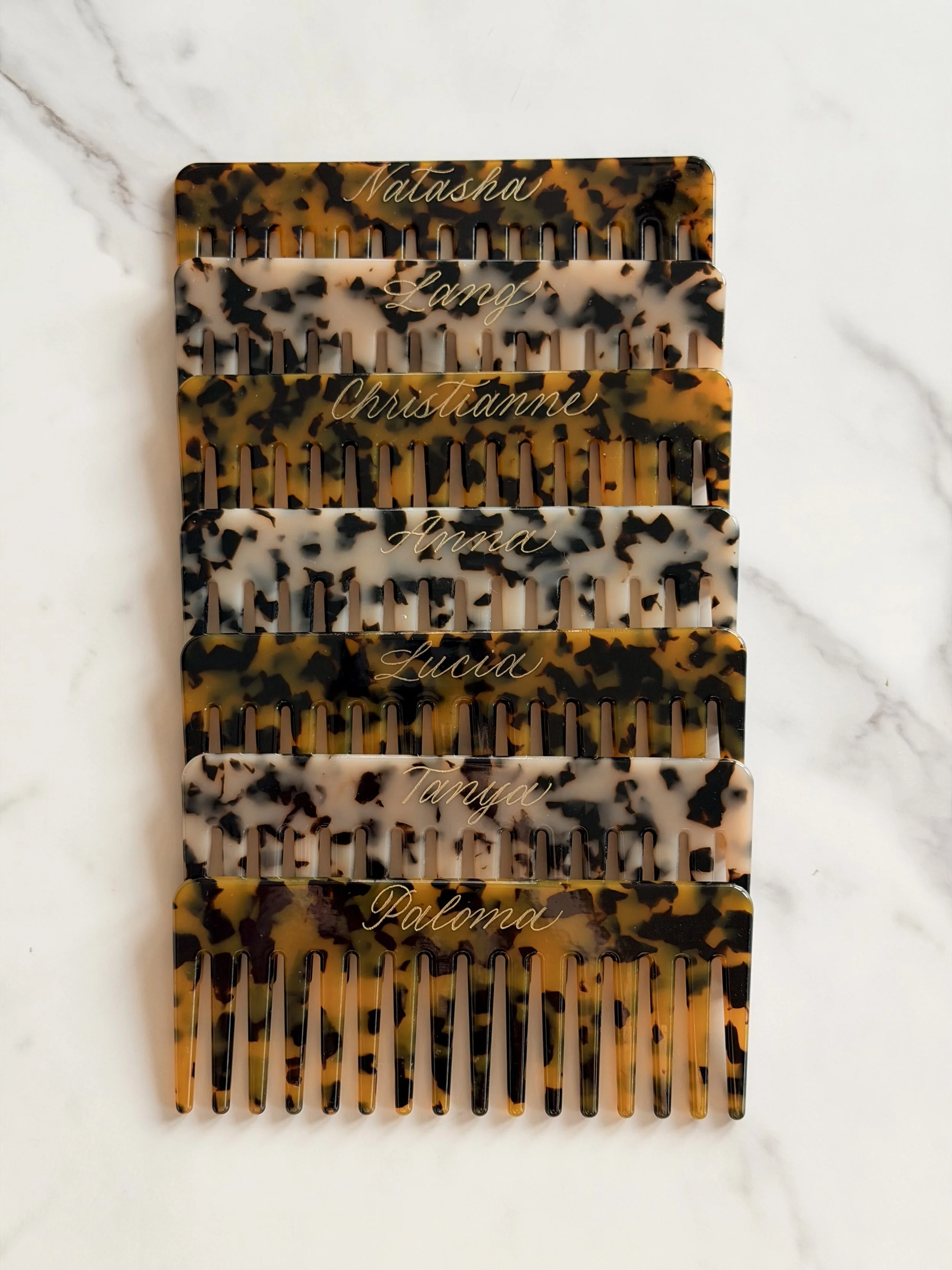 Tortoise hair combs personalized with individual names in custom gold calligraphy.