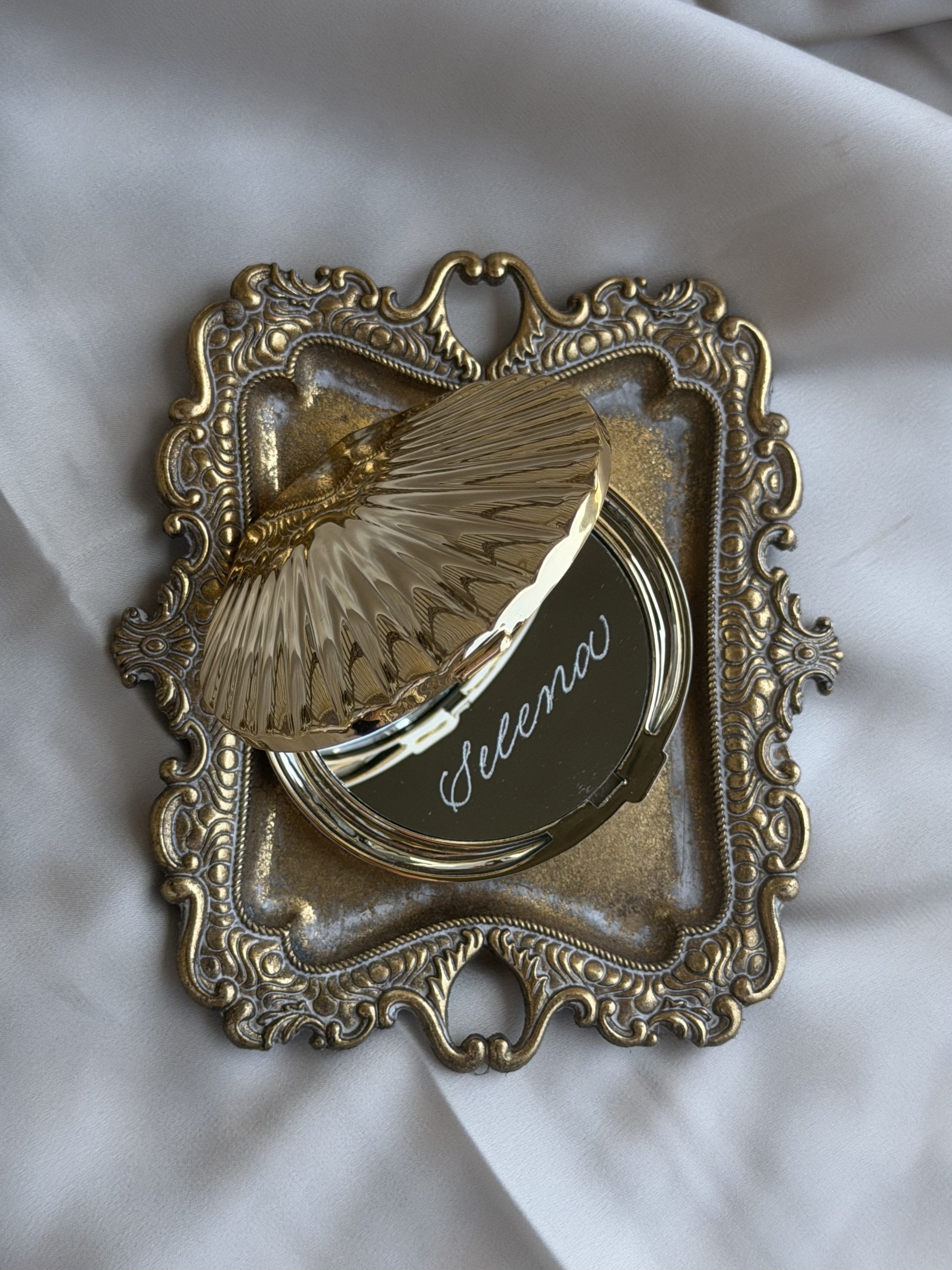 Seashell compact mirror personalized with hand lettering.
