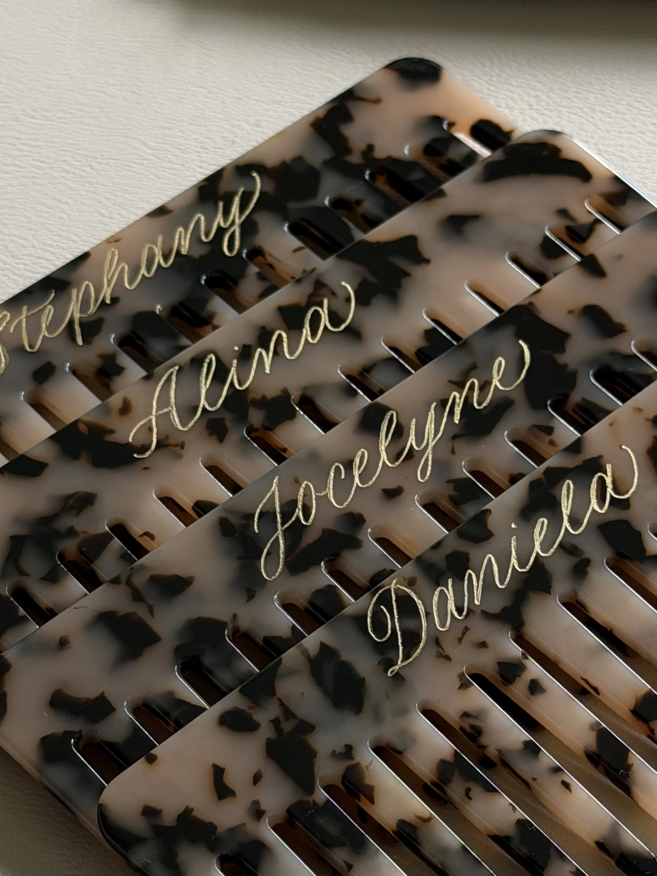 Tortoise hair combs personalized with custom gold calligraphy.