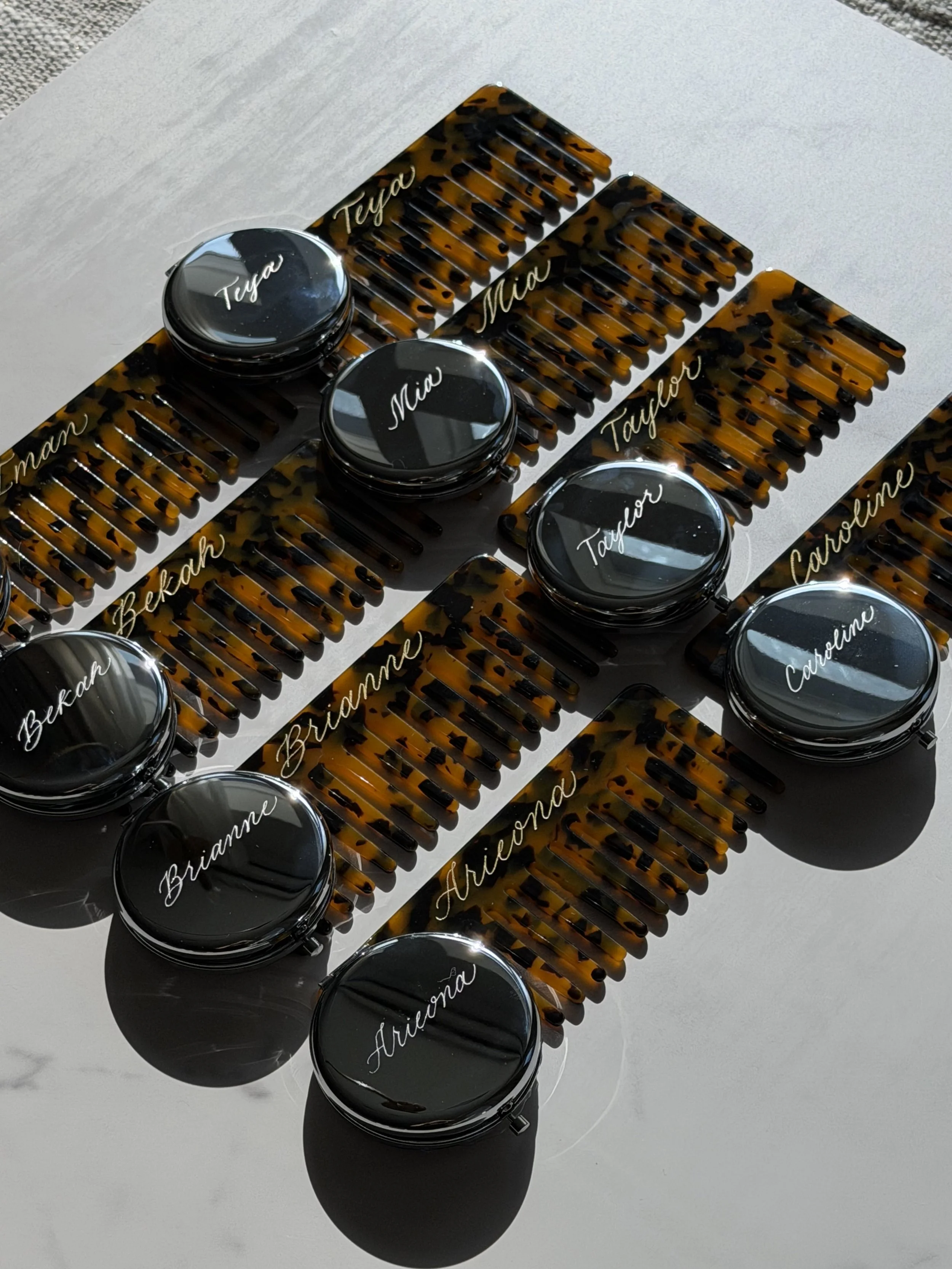 Personalized tortoise hair combs and round compact mirrors with individual names in custom lettering.