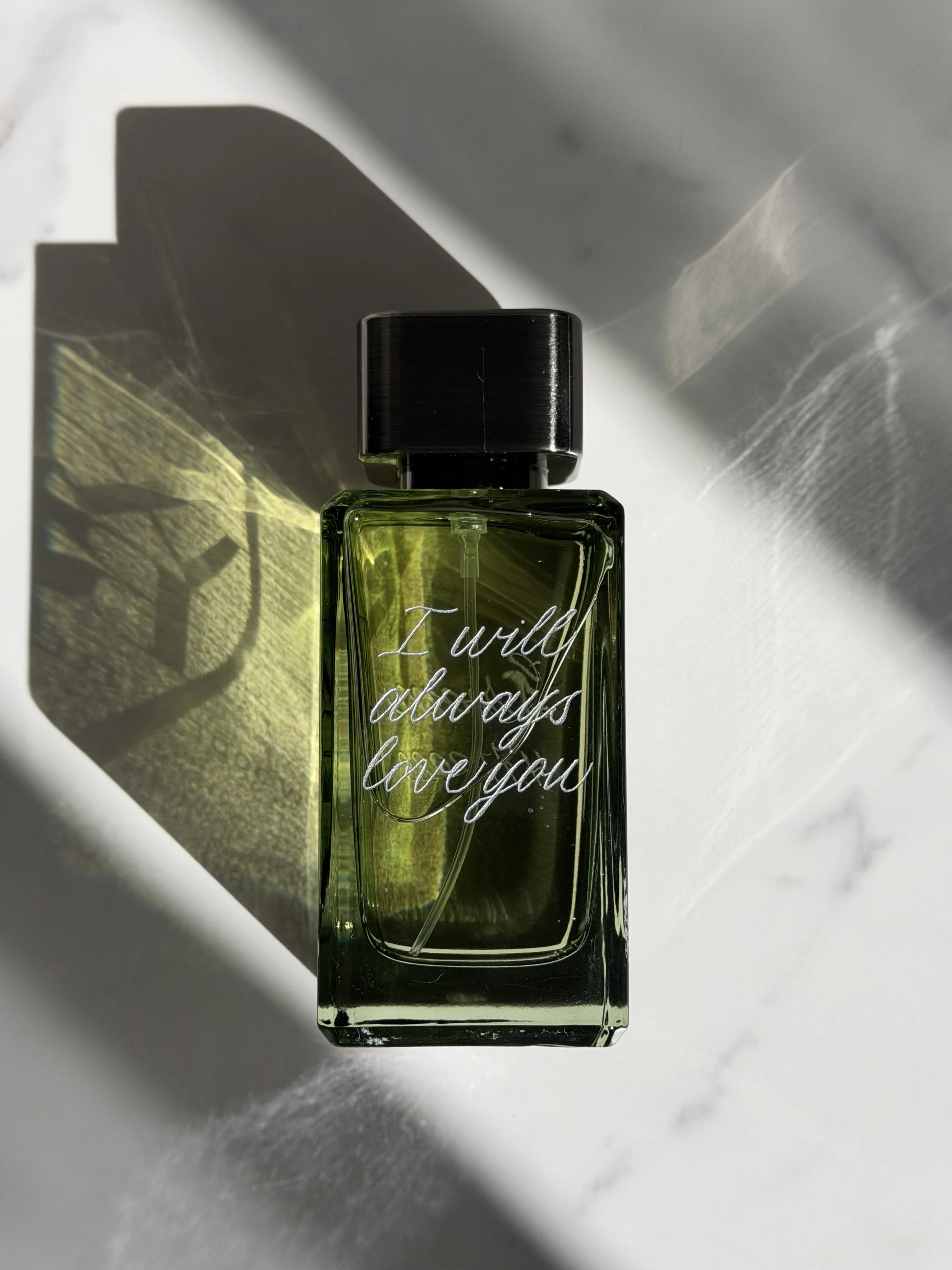 Green fragrance bottle personalized with a meaningful message in custom hand engraving.