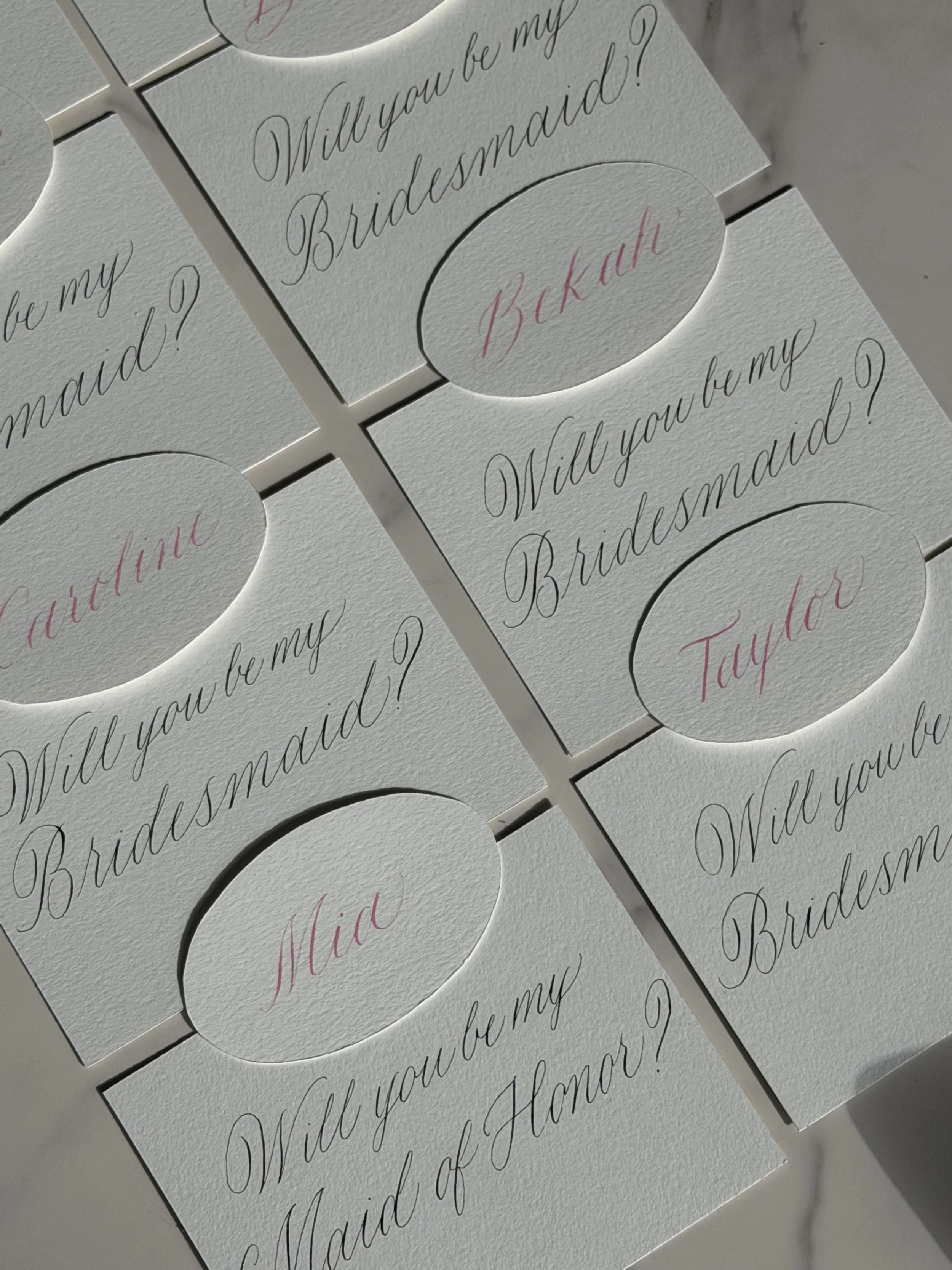 Bridesmaid proposal cards hand-lettered with custom calligraphy and individual names.
