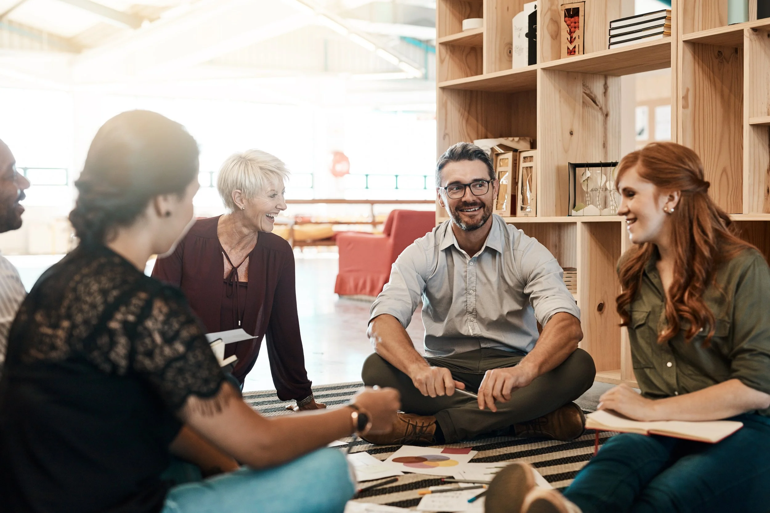 Business colleagues sitting on the floor, talking