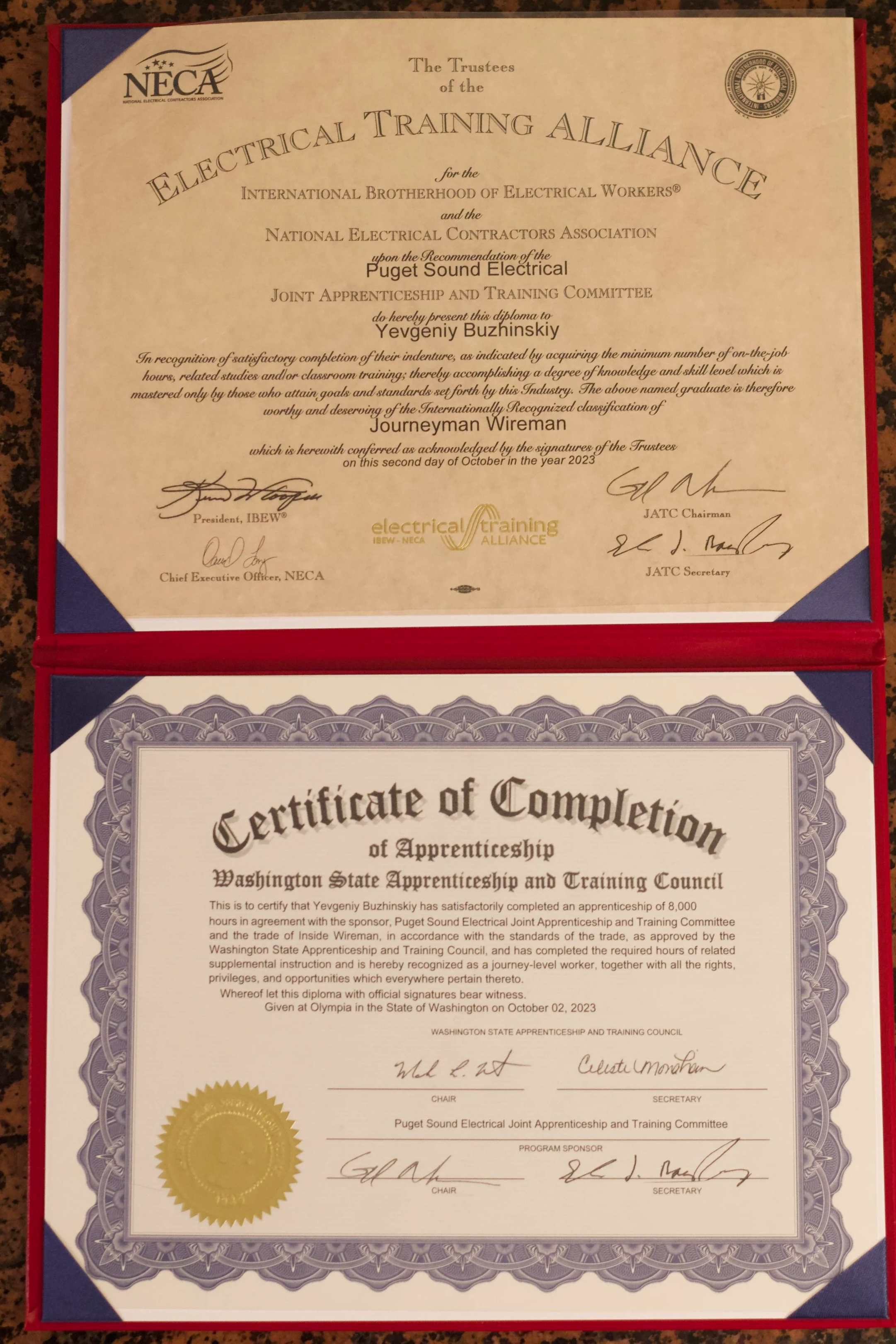 Diploma certificates from the Electrical Training Alliance and Washington State Apprenticeship and Training Council awarded to Yevgeniy Buzhinskiy for completing an apprenticeship. The top certificate is from NECA, the bottom from the Washington Stat