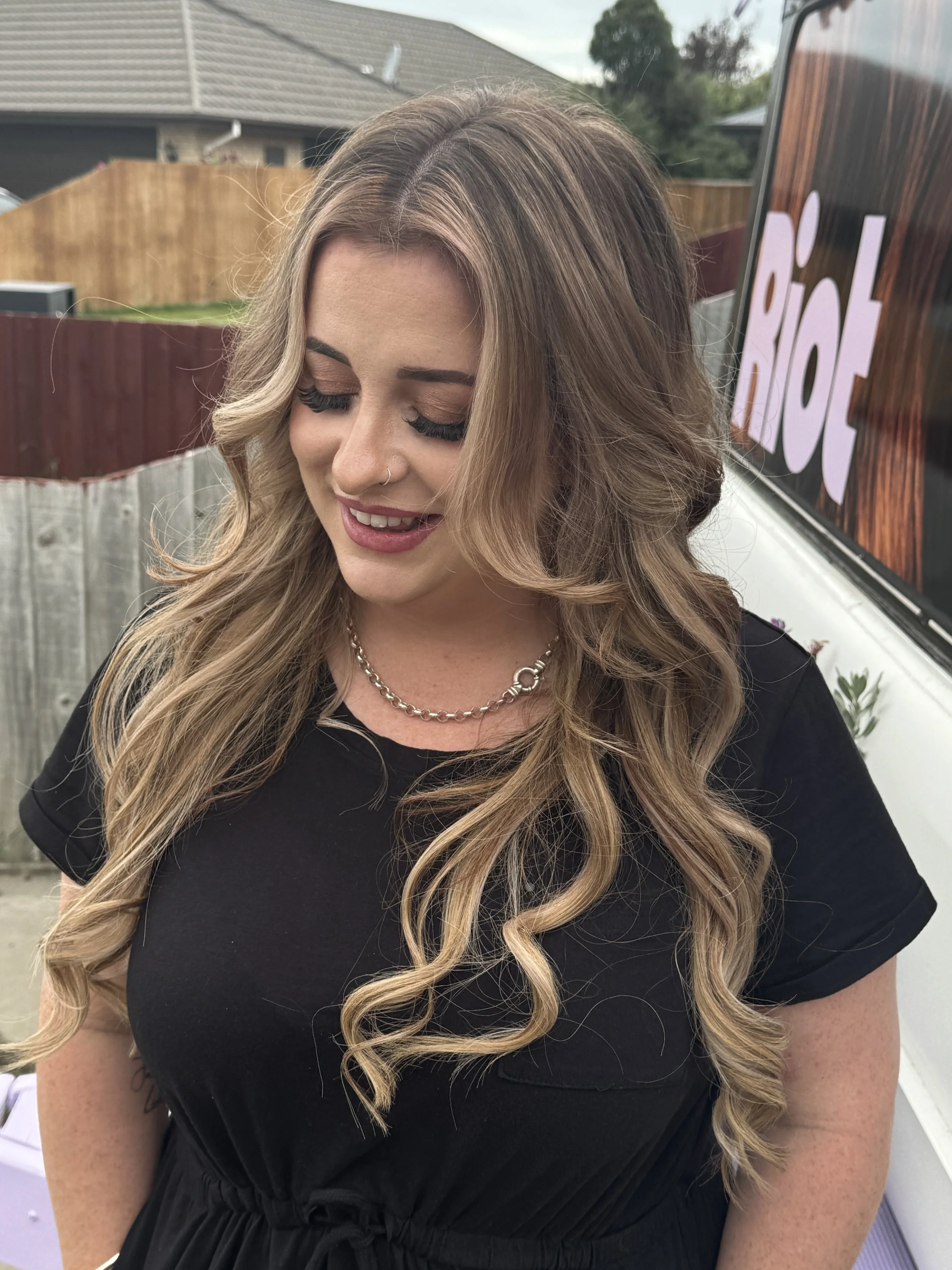 A woman with long, wavy blond hair with hair extensions in Christchurch