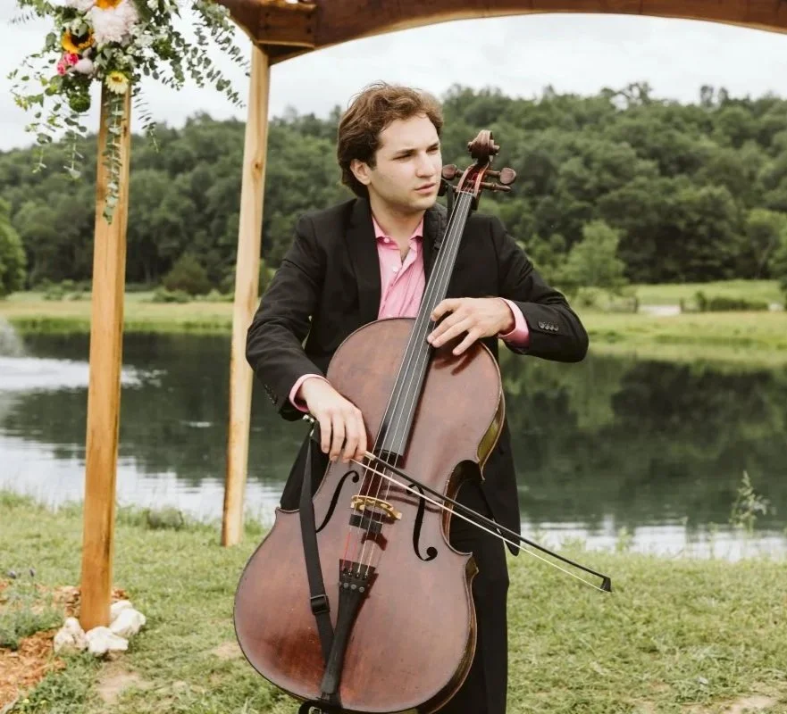 Action shot of a wedding cellist performing live music for guests arriving at a St. Louis ceremony.