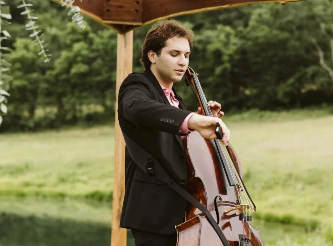A wedding cellist in formal attire standing beneath the altar, playing elegant live wedding music for a St. Louis ceremony.