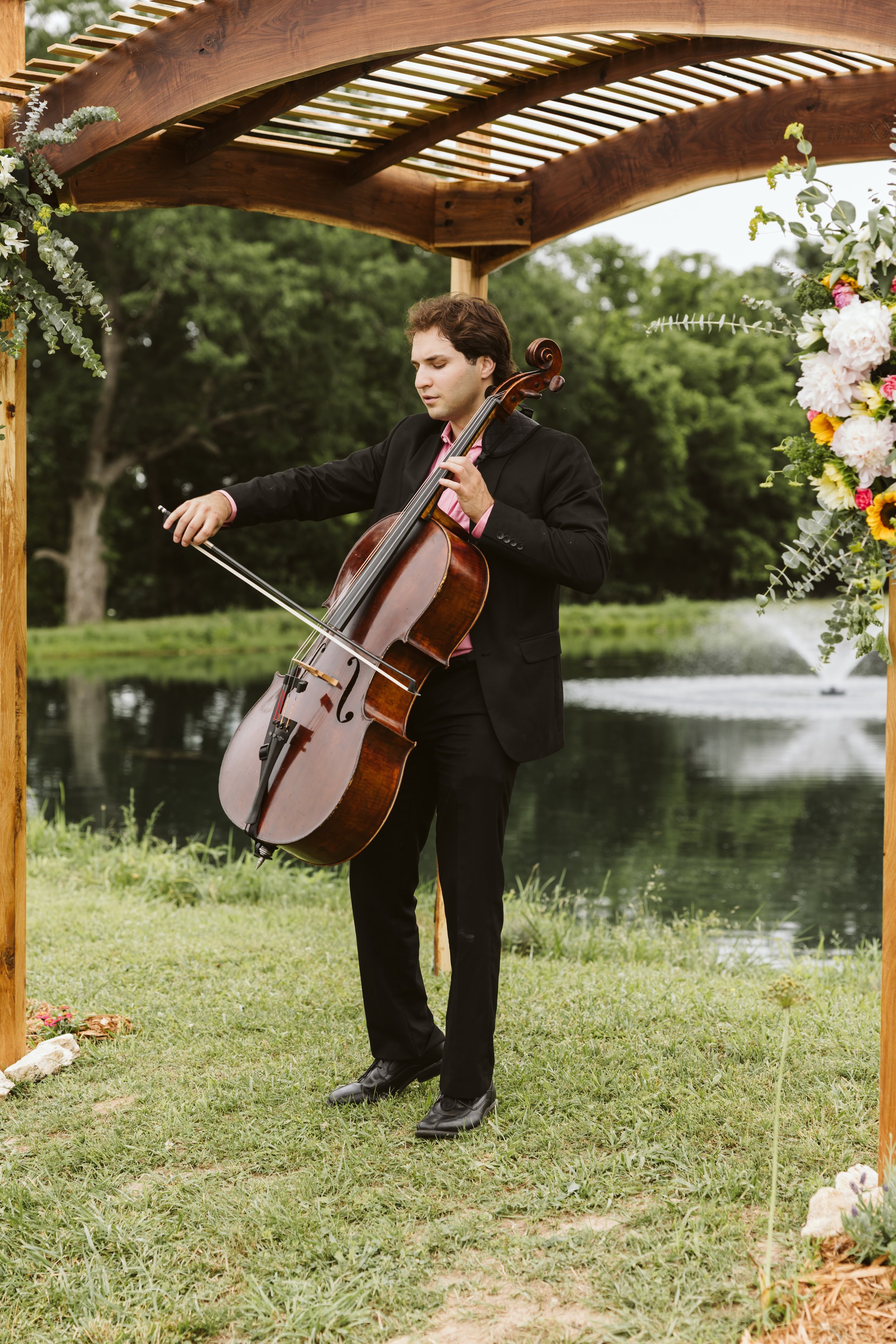 Action shot of a cellist performing a solo during a St. Louis wedding processional.