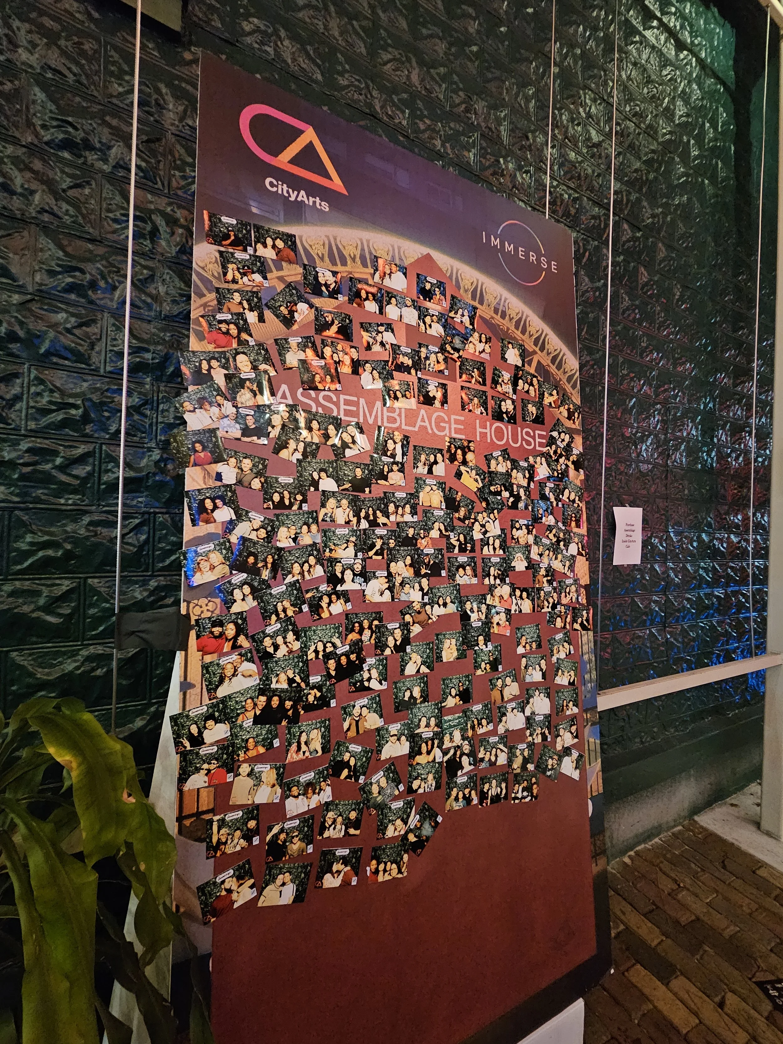 A collage of photographs on a display board at an event, with logos for CityArts and Immerse at the top, titled 'Assemblage House.'