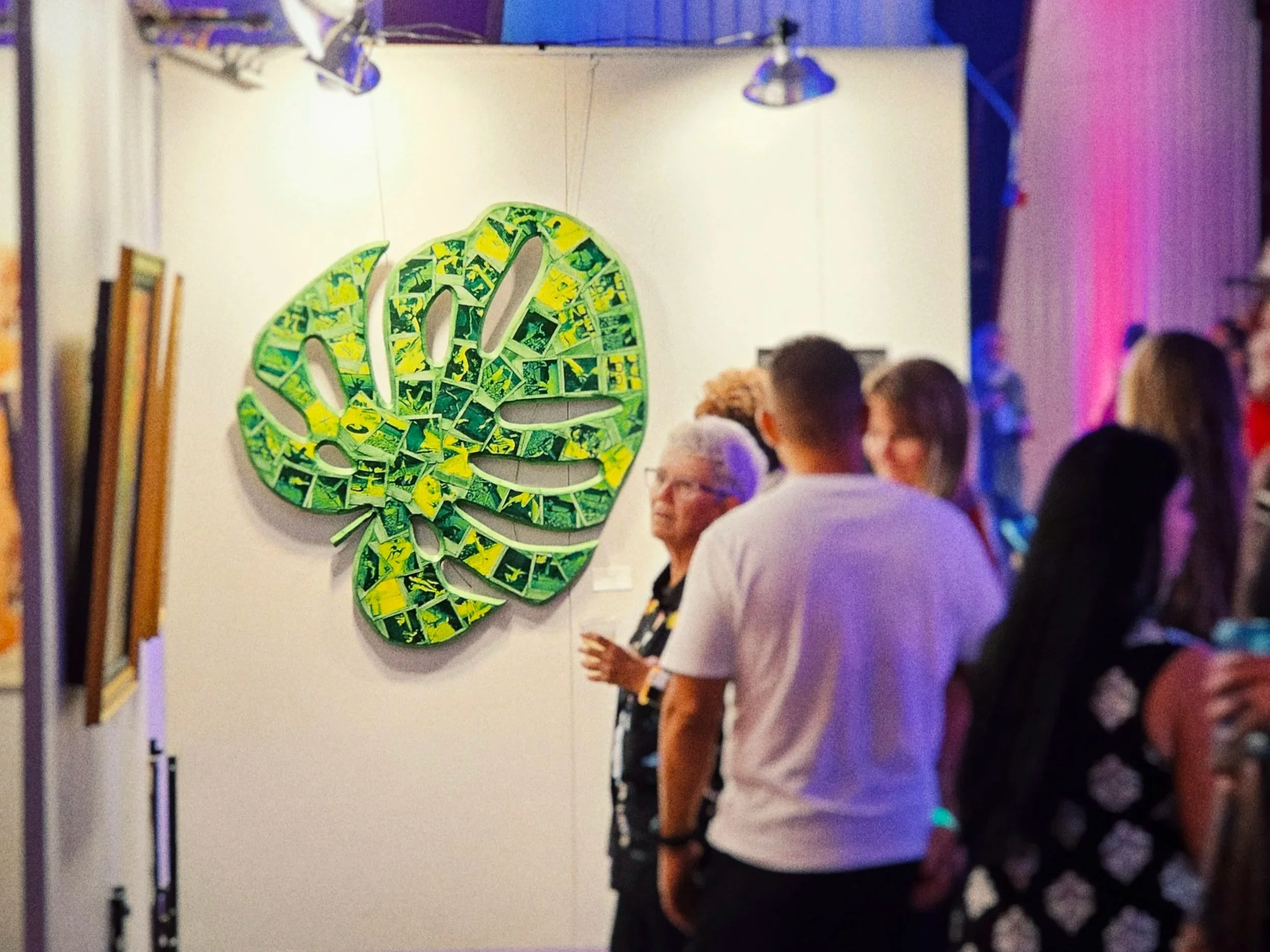 People viewing colorful art installations at an art gallery