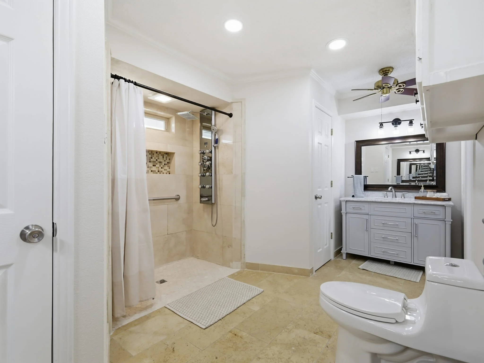 Bathroom with a walk-in shower, a toilet, and a vanity with a mirror.