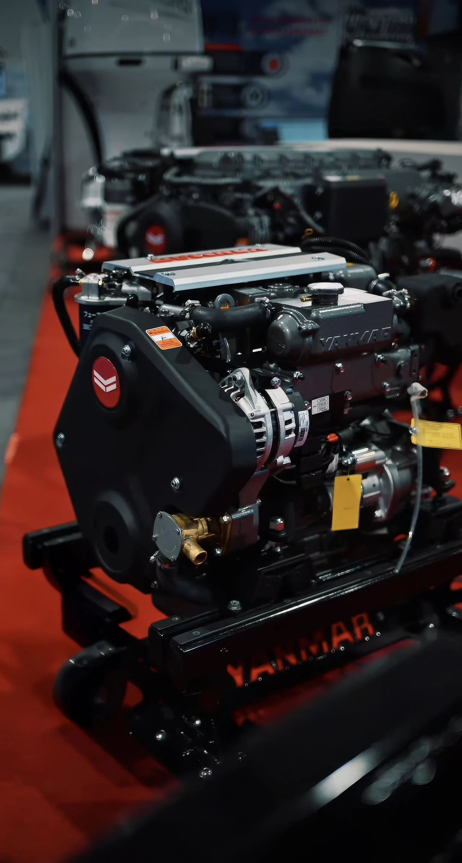 A racing car engine on display on a red surface in a workshop or garage